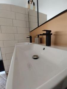 a white bathroom with a sink and a mirror at Maison centre historique Figeac in Figeac