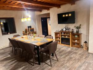 a dining room with a table with chairs and a television at Serenity Colibița in Colibiţa