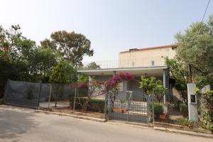 a house with a fence in front of it at Lia Beach house near airport in Artemida +17 photos
