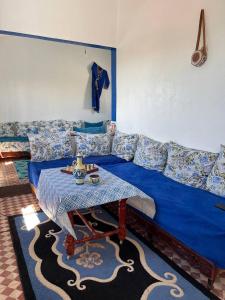a living room with a blue couch and a table at Dar nadia in Douar Sidi Brahim