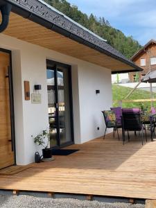 a house with a wooden deck with a table and chairs at Rosa Alpina Appartement in Bürserberg