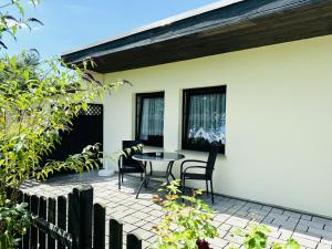eine Terrasse mit einem Tisch und Stühlen auf einem Haus in der Unterkunft F-1112 Ferienwohnung Lobbe Haus strandnah, Terrasse in Lobbe