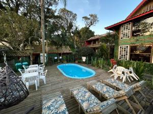 a patio with chairs and a swimming pool at Pousada Canoa Azul na Praia da Ferrugem in Garopaba