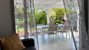 a dining room with a table and chairs on a patio at Villa Pradel Dylis in Saint-François