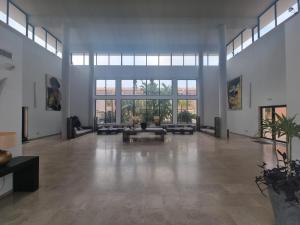 una gran sala de estar con una gran habitación con ventanas en Enebrales Home, en Punta Umbría