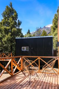 a house with two chairs on a deck at Refugio del Hornero Norte in San Carlos de Bariloche