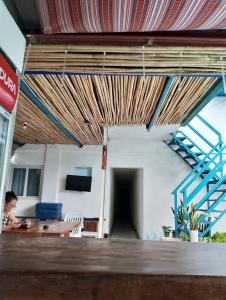 a person sitting at a table in a room with a staircase at Casa Montemar Heights in Coron