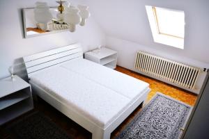 a white bed in a room with a window at Dom pod zámkom in Bojnice