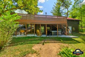 una pequeña casa con una gran terraza en un patio en Autumn Breeze Cabin, en Nashville