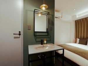 大阪市にあるR Hotel Namba Daikokuchoのバスルーム(シンク、ベッド、鏡付)