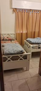 Habitación con 2 camas y cortina en comodidad y seguridad, en Ciudad Evita