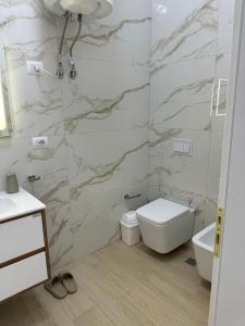 a bathroom with a shower and a toilet and a sink at Hi Mare Apartments 2 in Himare