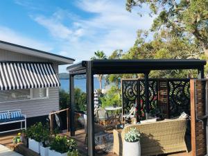 een pergola op een terras naast een huis bij Courtyard Pool Studio Private Luxe Retreat in Coal Point