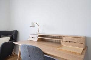 a desk with a lamp and two chairs in a room at Modern 1-Bed Unit with Pool Views and Balcony in Canberra