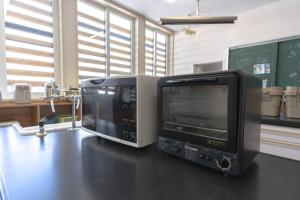 a microwave and a television sitting on a table at ペコレラ学舎 Pekolela YAKUMO in Yakumo