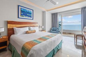 a bedroom with a bed and a view of the ocean at Blue Horizon Luxury Condo in Puerto Vallarta +46 photos