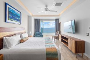 a hotel room with a bed and a television at Blue Horizon Luxury Condo in Puerto Vallarta