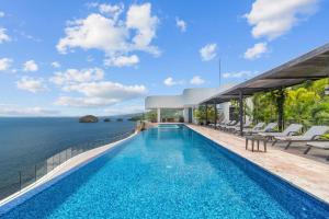 a pool on the edge of a house overlooking the ocean at Blue Horizon Luxury Condo in Puerto Vallarta