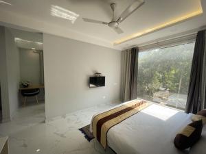古尔冈The Empire Corporate Villa Hotel Sector 29 near Fortis and Max Hospitals,Huda City Metros Station的一间卧室，配有一张大床和一扇大窗户。