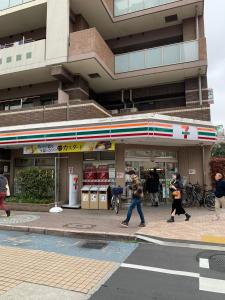 a group of people walking in front of a gas station at 703 Family room Near Kiowa station walk 1min in Tokyo