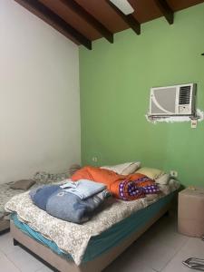 a bed in a room with a green wall at Habitacion privada en casa familiar in San Bernardino