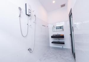 a white bathroom with a shower and a sink at Nine Homestay in Can Tho +68 photos