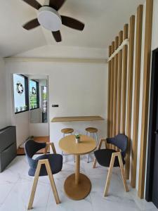 a room with a table and chairs and a ceiling fan at Haru Inn Airport in Ban Bo Han