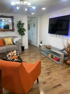 a living room with a couch and a flat screen tv at Serenity Guest Suite in Pocatello in Pocatello