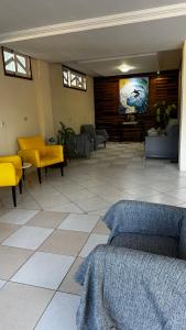 a living room with yellow furniture and a flat screen tv at Hotel Morada de Leste Pontal in Pontal do Paraná