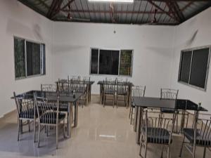 une pièce avec des tables et des chaises dans un bâtiment dans l'établissement Jaldapara Eco Resorts by StayApart, à Mādāri Hāt