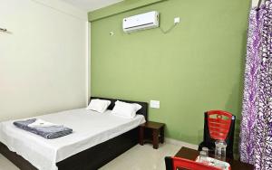 une petite pièce avec un lit et une chaise dans l'établissement Jaldapara Eco Resorts by StayApart, à Mādāri Hāt