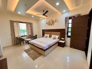a bedroom with a bed and a table and a chair at Vaidehi Resorts in Ayodhya