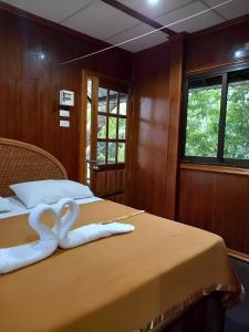 deux cygnes faits de serviettes sur un lit dans l'établissement Khao Sok River Canoe&Resort, à Khao Sok 15 autres photos