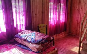 a bedroom with pink and purple curtains and a bed at Green Wings Homestay Sittong by StayApart in Mangpu +3 photos