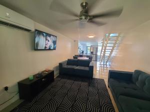 a living room with a couch and a tv at Deluxe Beach Condo in Dorado in Dorado