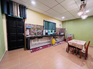 a dining room with a table and a table and chairs at Homestay Mamatok B in Kampong Kebun Tok Salim +15 photos