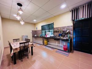 a dining room with a table and chairs and a counter at Homestay Mamatok B in Kampong Kebun Tok Salim