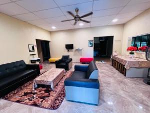 a living room with couches and a ceiling fan at Homestay Mamatok B in Kampong Kebun Tok Salim