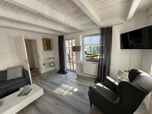 een woonkamer met een bank en een tv bij "Huus ant Diek", Ferienhaus mit Maisonette Wohnung in Deichnähe, Nähe Norddeich in Norden