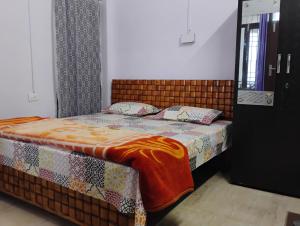 a bedroom with a bed with a blanket on it at Swaran bnb near Mcleodganj in Dharamshala +33 photos
