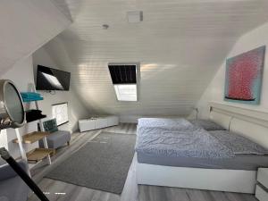 een slaapkamer met een bed op zolder bij "Huus ant Diek", Ferienhaus mit Maisonette Wohnung in Deichnähe, Nähe Norddeich in Norden