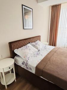a small bedroom with a bed and a table at Milescu Residence in Chişinău