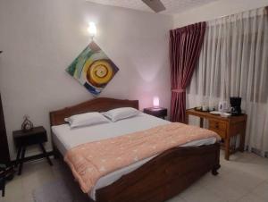 a bedroom with a bed and a painting on the wall at Sousa Residence in Bambalapitiya