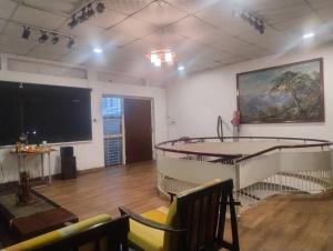 a room with a flat screen tv and chairs at Sousa Residence in Bambalapitiya
