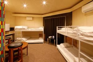 a room with bunk beds and a table and a stool at Starry Sky Cottage 13 in Kitami +46 photos