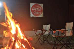 three chairs are sitting around a fire in a room at Starry Sky Cottage 13 in Kitami
