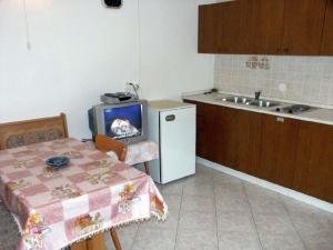 a kitchen with a table with a tv on it at One-Bedroom Apartment Crikvenica 14 in Dramalj