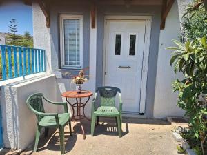 two chairs and a table on a porch with a door at Eve's house in Mokhós