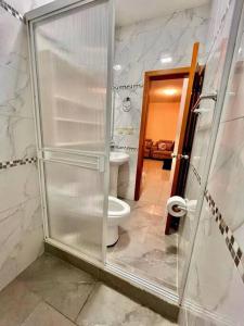 a bathroom with a toilet and a glass shower door at Apartamento Super Cómodo y Lujoso in Puerto Baquerizo Moreno