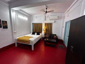 阿加尔塔拉Raj Andar Guest House的房间里有一张床和一张沙发的卧室